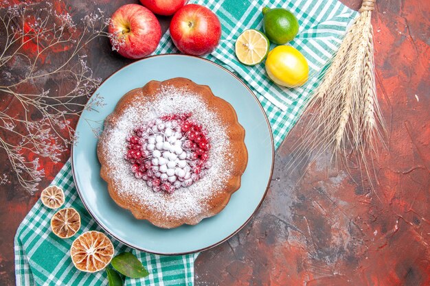 Top close-up view a cake a cake with berries powdered sugar citrus fruits apples wheat ears