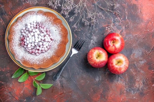 Top close-up view a cake a fork apples leaves the appetizing cake with red currants