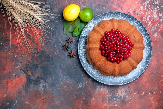 Top close-up view cake lemons limes leaves star anise cake with red currants wheat ears