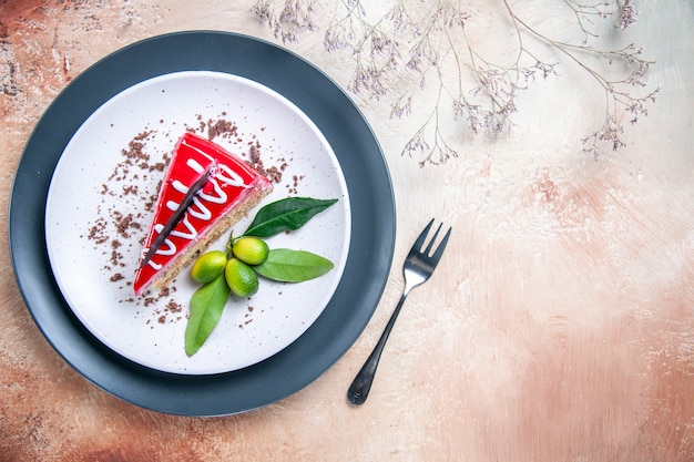 Top close-up view a cake plate of cake with chocolate sauces citrus fruits fork