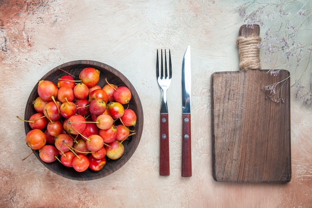 Top close-up view cherries the appetizing cherries in the bowl the cutting board fork knife