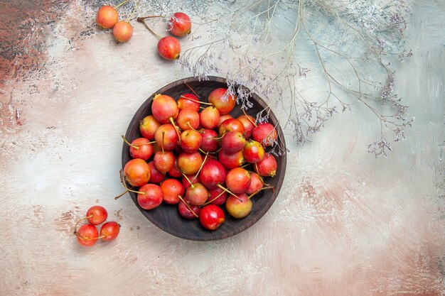 Top close-up view cherries bowl of the appetizing cherries tree branches