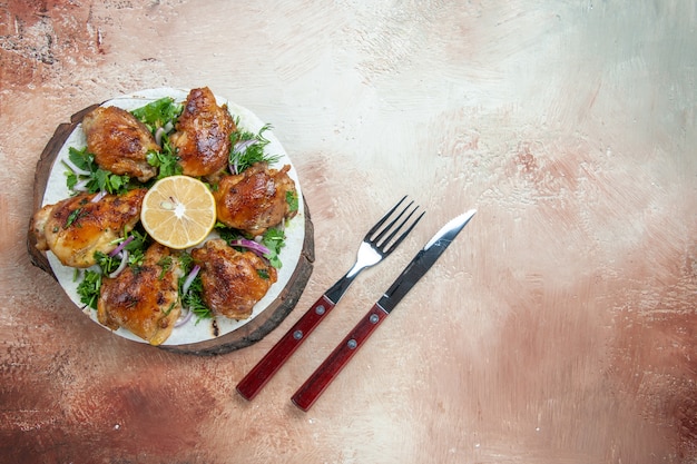 Free photo top close-up view chicken chicken with herbs and onion on the lavash on the board fork knife