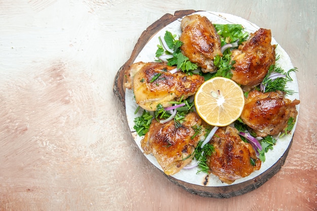 Top close-up view chicken chicken with lemon onion herbs on lavash