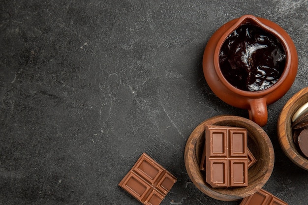 초콜릿과 초콜릿 소스의 검은색 테이블 갈색 그릇의 오른쪽에 있는 상위 클로즈업 보기 초콜릿 소스