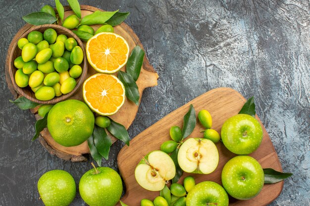 Top close-up view citrus fruits citrus fruits with leaves and apples on the boards