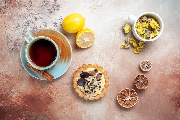 Top close-up view a cup of tea a cup of tea cinnamon lemon cupcake herbs