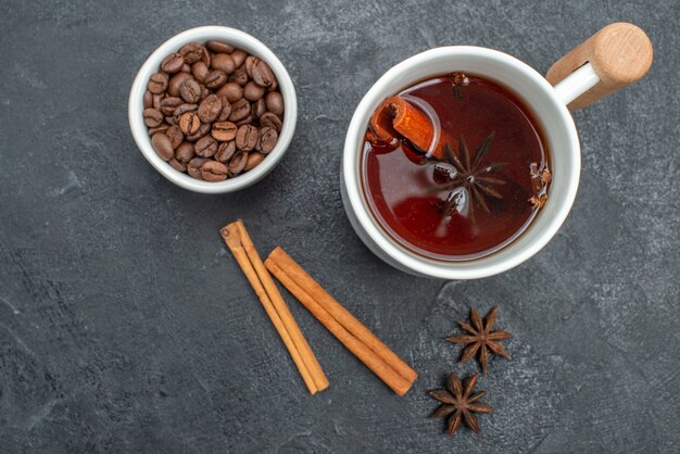 Top close-up view a cup of tea a cup of tea cinnamon sticks star anise coffee beans