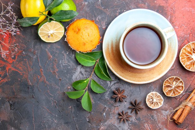 Вид сверху крупным планом чашка чая кекс чашка черного чая лимон звездчатый анис листья корицы ветки