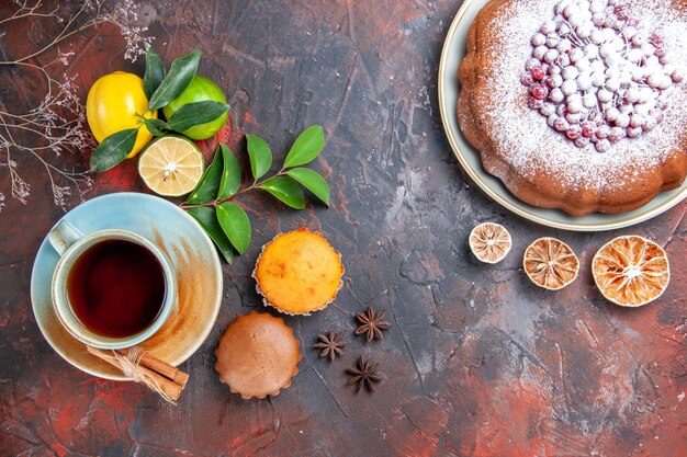 Top close-up view a cup of tea cupcakes a cup of tea cinnamon citrus fruits a cake star anise