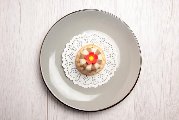 Верхний вид крупным планом кекс аппетитный кекс на кружевной салфетке на серой тарелке на белом столе
