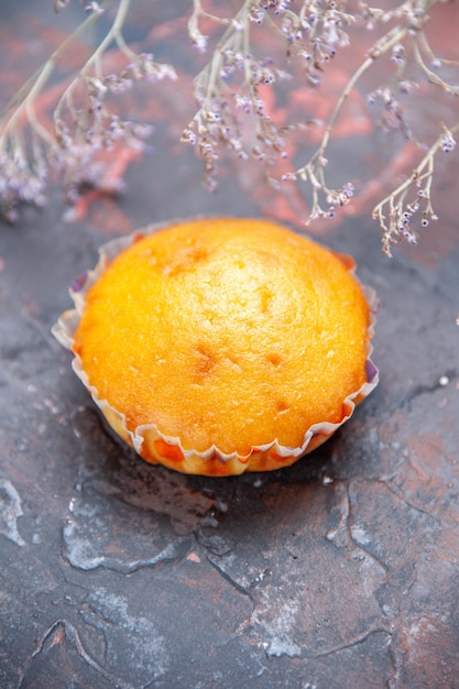 Free photo top close-up view cupcake an appetizing cupcake on the table next to the tree branches