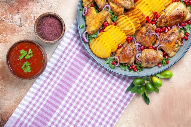 Free photo top close-up view dish sauce spices chicken wings potatoes on the white-purple tablecloth