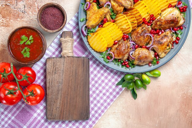 Top close-up view dish sauce spices tomatoes chicken with potatoes the cutting board