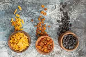 Free photo top close-up view dried fruits three brown bowls of the appetizing colorful dried fruits