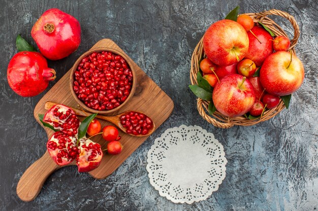 Top close-up view fruits basket of fruits the board with pomegranate spoon cherries lace doily