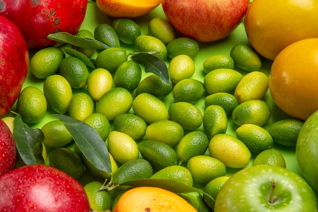 Top close-up view fruits citrus fruits apples pomegranates persimmons on the table