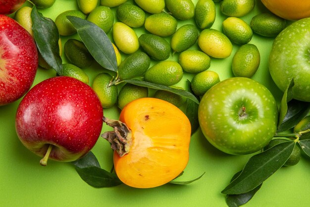 Top close-up view fruits citrus fruits red and green apples persimmons