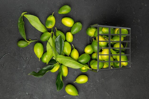 Top close-up view fruits citrus fruits with leaves next to the basket