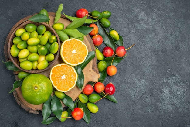 Top close-up view fruits the cutting board with citrus fruits with leaves