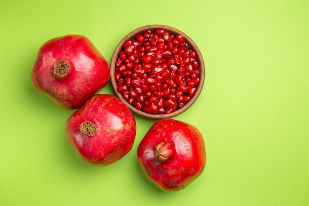 Top close-up view fruits seeds of pomegranate the appetizing apples on the green surface