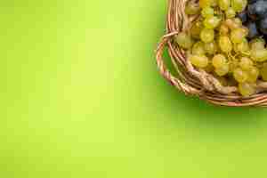 Free photo top close-up view grapes bunches of grapes in the wooden basket on the green background