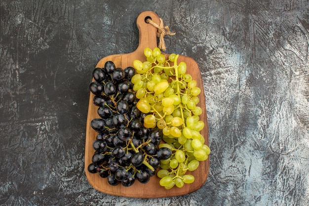 Top close-up view grapes bunches of green and black grapes on the board