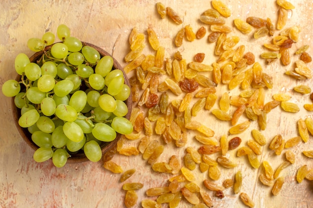 Top close-up view grapes green grapes in the bowl and raisins