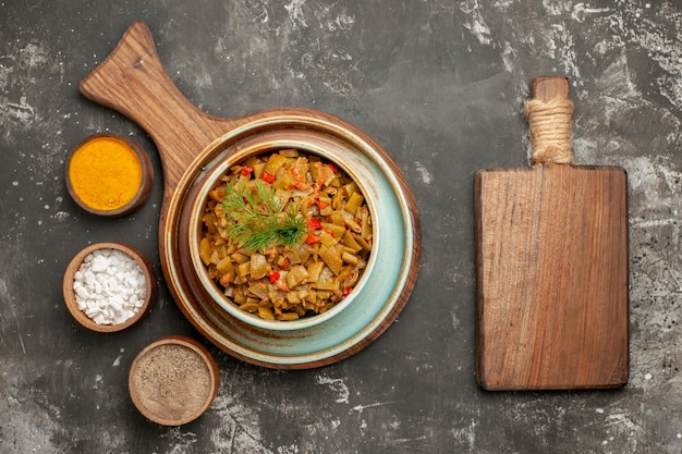 Vista ravvicinata dall'alto fagiolini con tagliere di pomodori accanto al tagliere con piatto di fagiolini e tre spezie