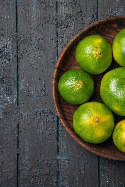 Free photo top close-up view green-yellow limes green-yellow limes on grey table