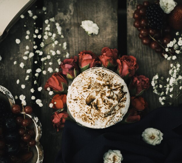 赤いバラと茶色の木製の素朴な表面のビューホットコーヒーおいしいトップを閉じる