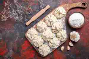 Free photo top close-up view khinkali the appetizing khinkali on the cutting board garlic bowl of flour