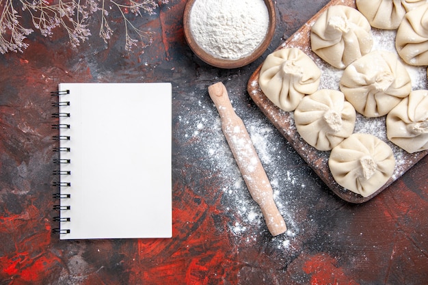 Top close-up view khinkali khinkali on the board flour rolling pin notebook