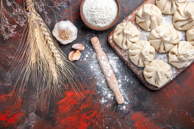 Top close-up view khinkali khinkali on the board rolling pin garlic flour