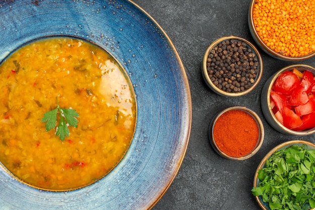 Foto gratuita top vista ravvicinata zuppa di lenticchie zuppa di lenticchie spezie erbe pomodori lenticchie sul tavolo
