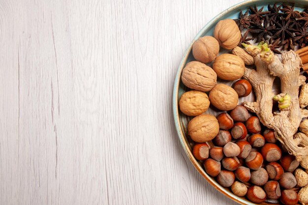 Top close-up view nuts hazelnuts walnuts peanuts cinnamon sticks and star anise on the table