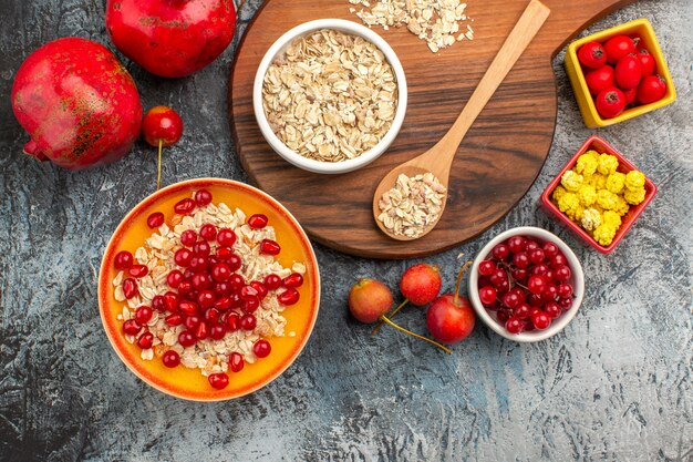 Top close-up view oatmeal the appetizing pomegranates berries oatmeal on the board