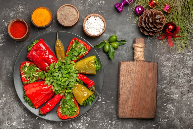 Top close-up view peppers wooden board plate of peppers Christmas tree toys colorful spices