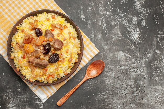 Top close-up view pilaf an appetizing pilaf on the checkered tablecloth spoon