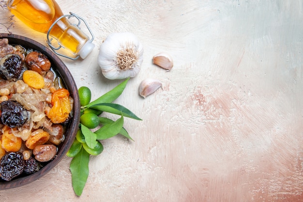 Free photo top close-up view pilaf an appetizing rice with dried fruits bottle of oil citrus fruits garlic