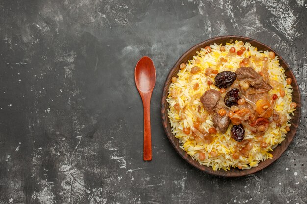 쌀 고기와 말린 과일의 상위 클로즈업보기 필라프 숟가락 그릇