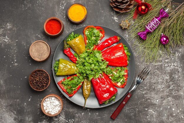 Top close-up view plate of peppers the appetizing peppers spices fork cone Christmas toys