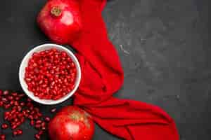 Free photo top close-up view pomegranate red ripe pomegranates pomegranate seeds in the bowl red tablecloth