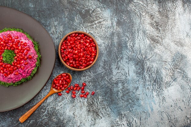 Top close-up view pomegranates an appetizing dish and bowl of pomegranate seeds