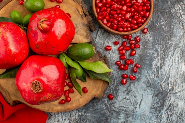 Top close-up view pomegranates appetizing pomegranates on the wooden board pomegranate seeds