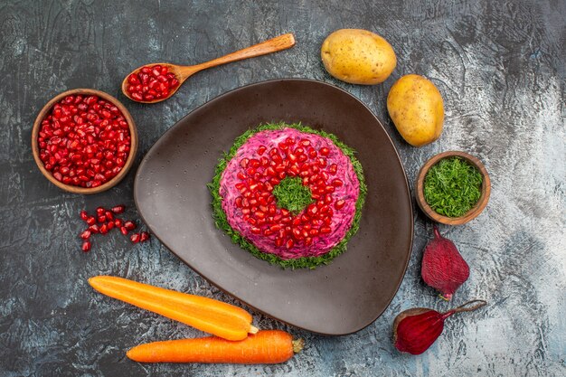 Top close-up view pomegranates dish bowl of pomegranate seeds herbs vegetables