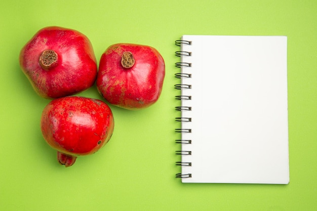 Top close-up view pomegranates red ripe pomegranates next to the white notebook