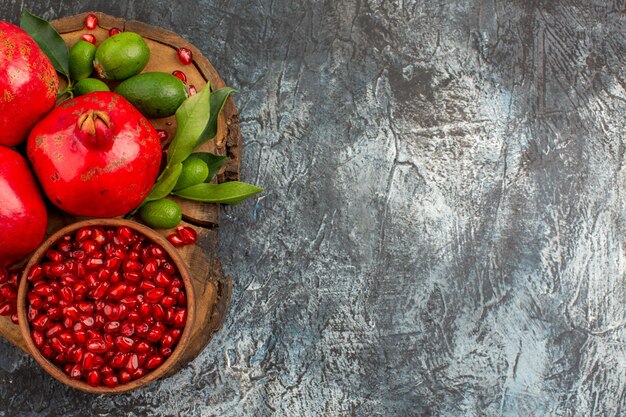 Top close-up view pomegranates seeds of pomegranate and three pomegranates on the kitchen board