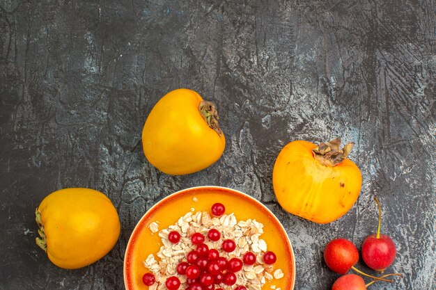 Top close-up view red currants persimmons berries red currants in the bowl