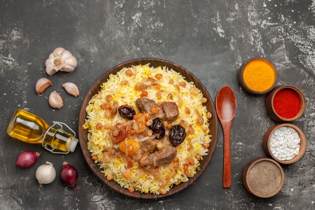 上部のクローズアップビュー米玉ねぎにんにくオイルスプーンのボトル食欲をそそるピラフスパイス